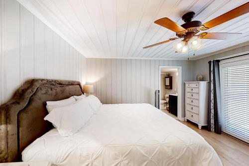 a bedroom with a bed with a ceiling fan at Little River Waterway Cottage Retreat in Little River
