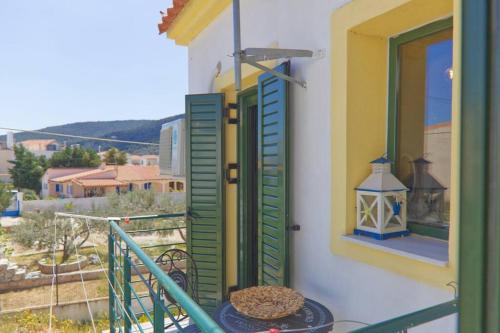 a balcony with green shutters and a plate of food at Sunset in Megalochori