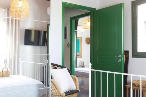 a green door in a bedroom with a bed and a tv at Sunset in Megalochori