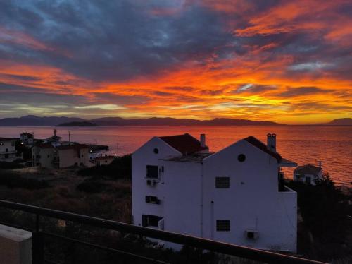 a white building with a sunset in the background at Sunset in Megalochori