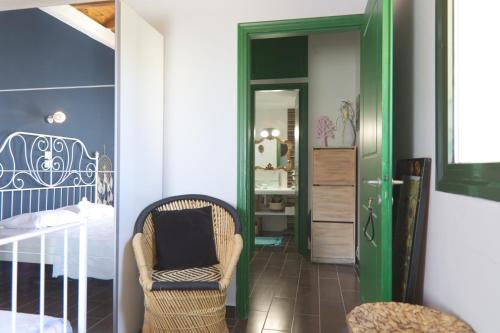 a bedroom with a bed and a chair and a mirror at Sunset in Megalochori