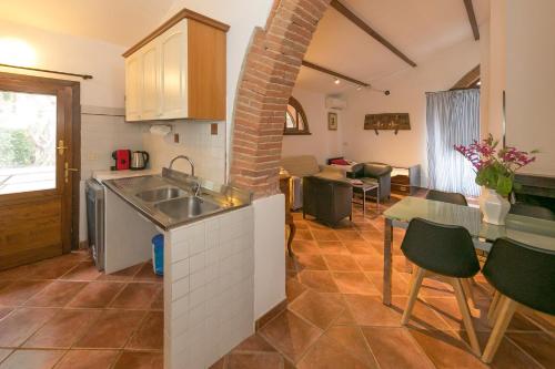 a kitchen with a sink and a table with chairs at Podere Isabella in San Vincenzo