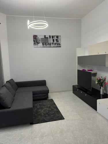 uma sala de estar com um sofá preto e uma televisão em Port House em Civitavecchia