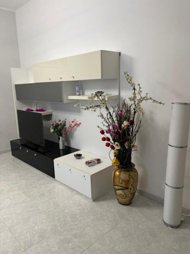 a living room with a vase with flowers in it at Port House in Civitavecchia