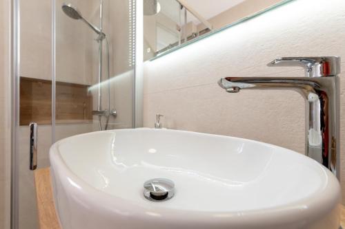 a white sink in a bathroom with a shower at Apartment Bellezza in Trogir