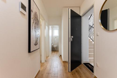 a hallway with a black door and a mirror at Apartment Bellezza in Trogir