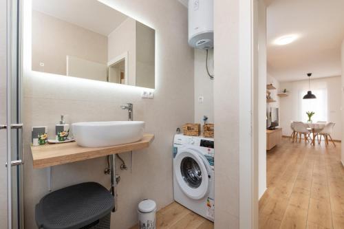 a bathroom with a sink and a washing machine at Apartment Bellezza in Trogir