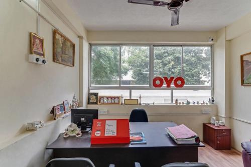 an office with a desk with a laptop and a window at OYO Flagship 15148 Sky Pix Near Kasi Talkies in Chennai