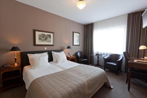 um quarto de hotel com uma cama e uma secretária em Hotel De Hofkamers em Oostende