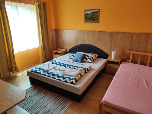 1 dormitorio con cama y ventana en Hotel Béke Sziget Komló, en Komló