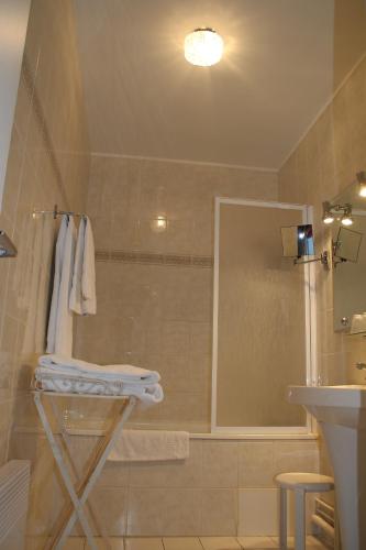 a bathroom with a sink and a shower with towels at Les Colonnes in Saint-Martin-de-Ré