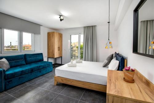 a living room with a bed and a blue couch at Linden Apartments in Potos