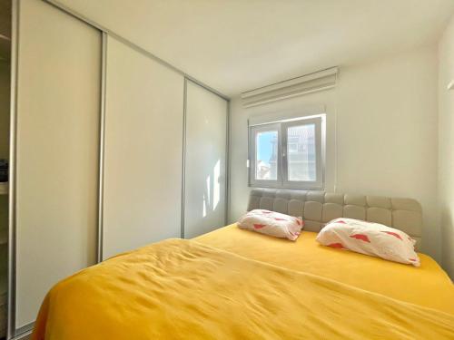 a bedroom with a large yellow bed with two pillows at Family One bedroom apartment with Garden view in Budva