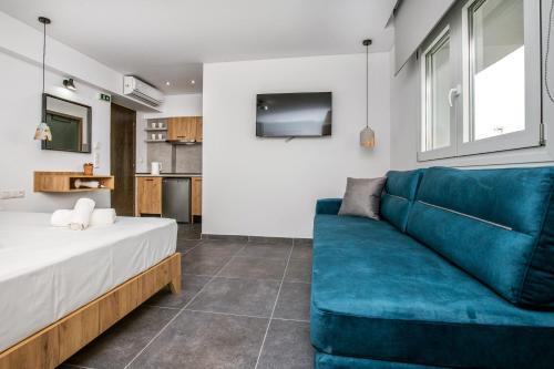 a living room with a blue couch and a tv at Linden Apartments in Potos