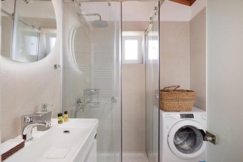 a bathroom with a shower and a washing machine at MM luxury studios&villas in Kompítsion