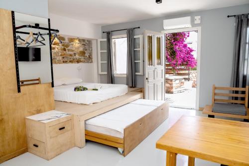 1 Schlafzimmer mit 2 Betten und einem Tisch in der Unterkunft Axilleion Guest House in Ermoupoli