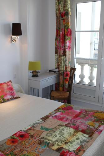 a bedroom with a bed and a desk and a window at Les Colonnes in Saint-Martin-de-Ré