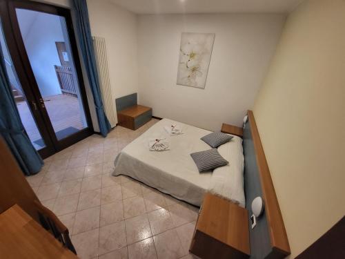 niewielka sypialnia z łóżkiem i oknem w obiekcie Residence Villa Margherita w Brenzone sul Garda