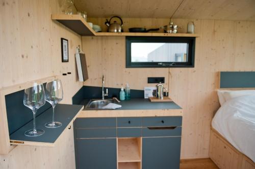 a small kitchen with a sink and two wine glasses at Sleep Space 2 - Green Tiny Spot Dolmar 