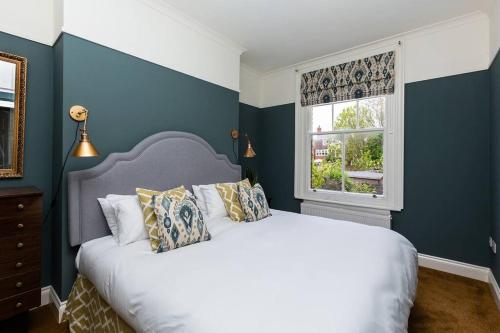 um quarto com uma cama branca e uma janela em Harriet - Quaint one bedroom apartment with easy parking em Kent