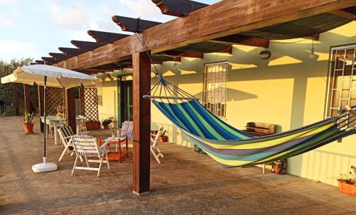 een hangmat hangend aan een luifel op een patio bij Villa Tramonto in Alghero