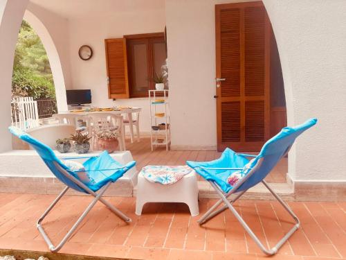 two blue chairs on a patio with a table at Antonia's Home - casa per le vacanze con giardino e veranda attrezzati in San Domino