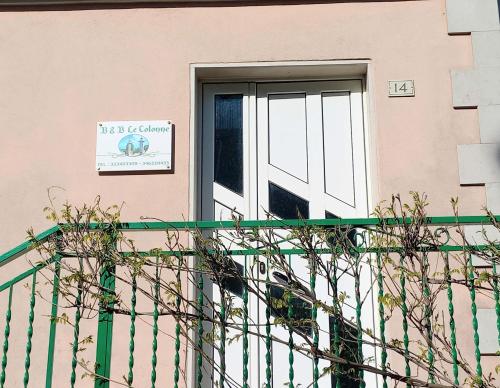 a pink building with a door with a sign on it at B&B Le Colonne in Montefusco