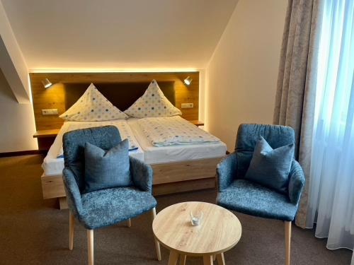 - une chambre avec un lit, deux chaises et une table dans l'établissement Gasthaus Zur Erle, à Simonswald