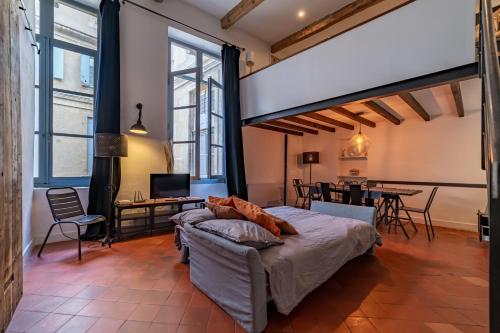 - une chambre avec un grand lit et un coin repas dans l'établissement Loft calme à la Maison Carrée - Une Nuit à Nîmes, à Nîmes