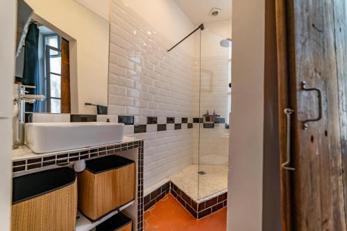 La salle de bains est pourvue d'un lavabo et d'une douche. dans l'établissement Loft calme à la Maison Carrée - Une Nuit à Nîmes, à Nîmes