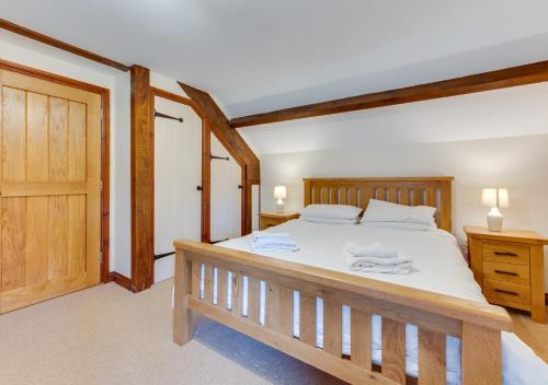 1 dormitorio con cama de madera y puerta de madera en Canoldy en Builth Wells