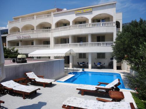a hotel with a swimming pool in front of a building at Villa Daniela in Bol