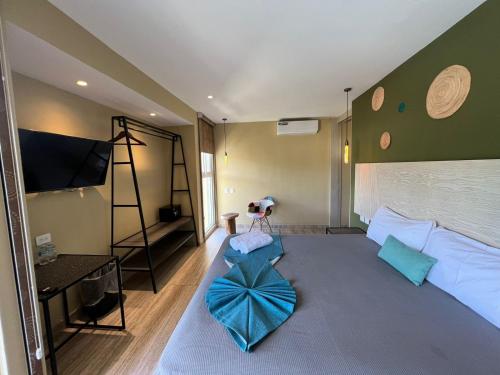 LOL-HA Hotel Boutique في كانكون: غرفة نوم مع سرير أزرق كبير مع تلفزيون بشاشة مسطحة