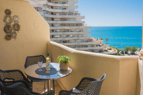 un balcón con mesa y sillas y un edificio en Espectacular apartamento. en Benalmádena