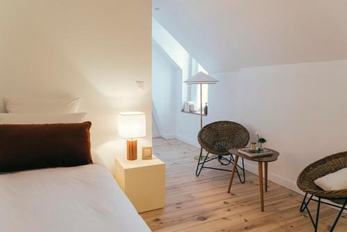 a bedroom with a bed and a table and chairs at La Papote in Bourron-Marlotte