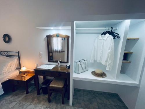 1 dormitorio con escritorio, espejo y cama en Venikouas Hotel, en Platis Yialos Sifnos