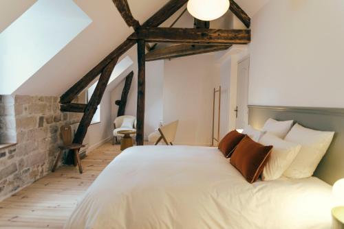 een slaapkamer met een groot wit bed in een loft bij La Papote in Bourron-Marlotte