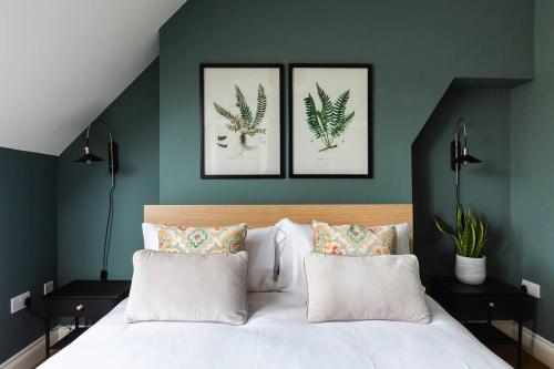 a bedroom with three pictures on the wall and a bed at Queenie - Charming one bedroom apartment in quiet location in Kent