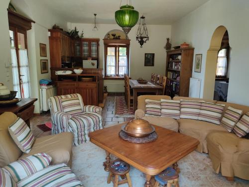 een woonkamer met banken en een salontafel bij White stone house with great sea view in Tsagarada