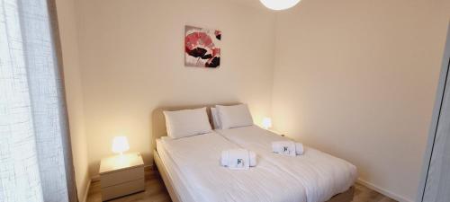 ein Schlafzimmer mit einem weißen Bett mit zwei Handtüchern darauf in der Unterkunft La Dolce Vita in Lugano