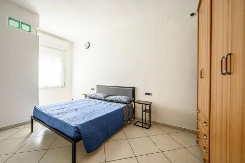 a bedroom with a bed with a blue comforter and a window at [Parking&Wifi free / Hesperia] Groundfloor Oasis in Modena