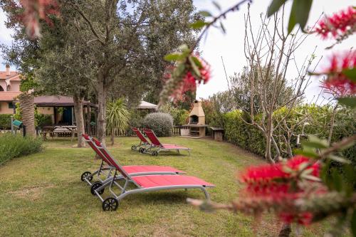 two red chairs in a yard with a gazebo at Podere Isabella in San Vincenzo
