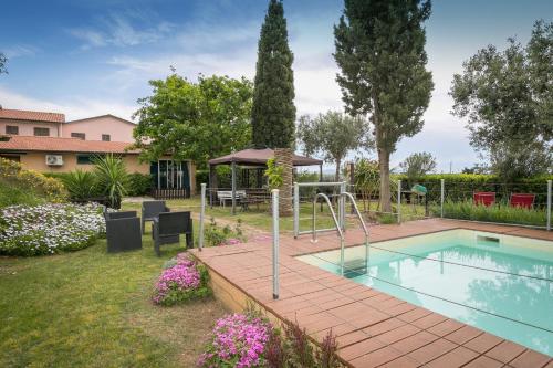 un patio trasero con piscina y parque infantil en Podere Isabella, en San Vincenzo