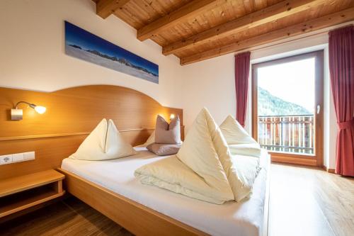 a bedroom with a bed with a large window at Apartments Nature Apis Landheim in Anterselva di Mezzo