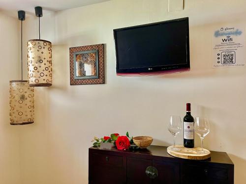 sala de estar con TV y mesa con copas de vino en Hostal - Restaurante Nomadas by Gloove, en Villalba de la Sierra