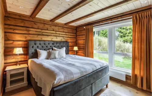 - une chambre avec un lit dans une cabane en rondins dans l'établissement Awesome Home In Hurdal With Wifi And 5 Bedrooms, à Hurdal