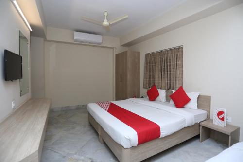 sypialnia z dużym łóżkiem z czerwonymi poduszkami w obiekcie Collection O Tulsi Palace w mieście Nagarbazar