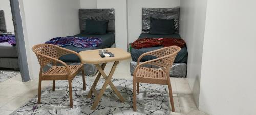 - une table et deux chaises dans une chambre avec un lit dans l'établissement Best Dreams Hotel, au Caire