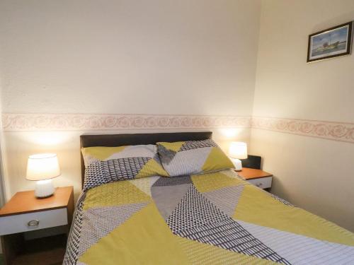 a bedroom with a bed with two night stands and two lamps at Sunnyside Holiday Apartment 1 in Bridlington