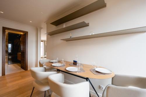 une salle à manger avec une table et des chaises blanches dans l'établissement Le Nid du Favre II - Large 2 room with breathtaking view of the lake, à Annecy